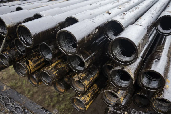 Olie boorpijp. In het putgedeelte werden roestige boorpijpen geboord. Beneden boorplatform. De pijp op het dek leggen. Zicht op de schelp van boorpijpen op de binnenplaats van het olie- en gasmagazijn. — Stockfoto