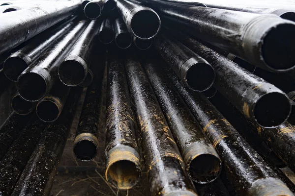 Oil Drill pipe. Rusty drill pipes were drilled in the well section. Downhole drilling rig. Laying the pipe on the deck. View of the shell of drill pipes laid in courtyard of the oil and gas warehouse. — Stock Photo, Image