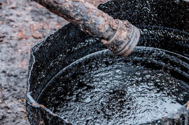 Kirli petrol yere dökülür. Petrol kirliliği.