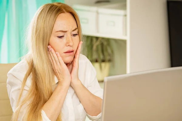 Stressed upset young business woman use laptop doing difficult task suffer from headache at work feel tired or bored, frustrated exhausted employee office worker fatigued from computer at workplace.