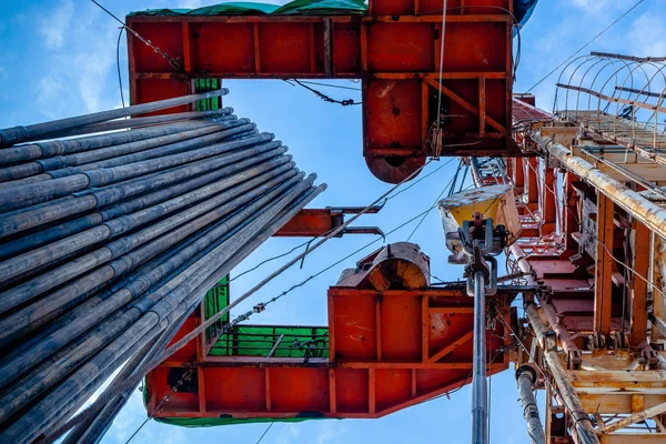 Parlak mavi gökyüzüne karşı petrol sahasında petrol platformu derrick. Petrol sahasında ham petrol üretimi için yeraltı sondaj kulesi. Petrol Sanayi