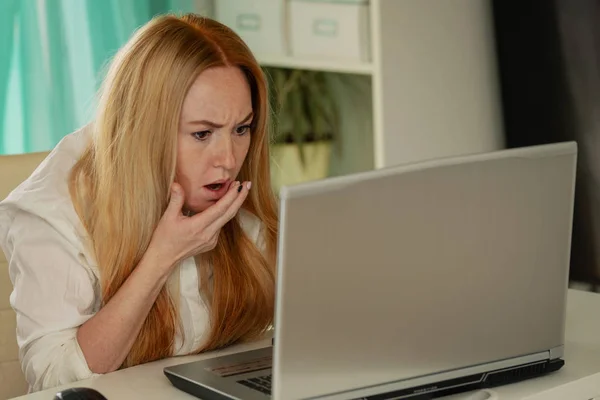 Μπερδεμένη νεαρή γυναίκα κοιτάζοντας στο laptop στο σπίτι νιώθοντας σαστισμένη από καμία σύνδεση, διαβάζοντας online ειδήσεις στο διαδίκτυο — Φωτογραφία Αρχείου