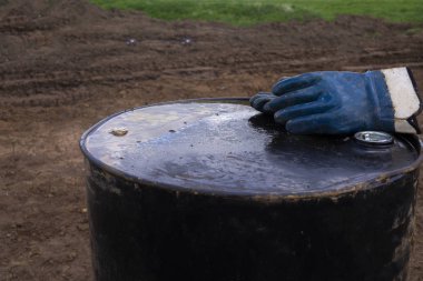 Paslı fıçıda kirli iş eldivenleri. Eldiven petrol içinde bir viski varil üstüne oturan