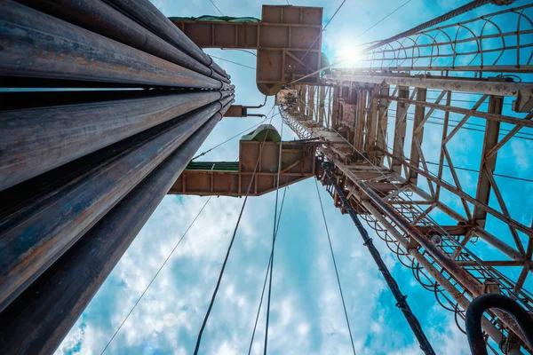 Oil and Gas Drilling Rig onshore dessert with dramatic cloudscape. Oil drilling rig operation on the oil platform in oil and gas industry — Stock Photo, Image