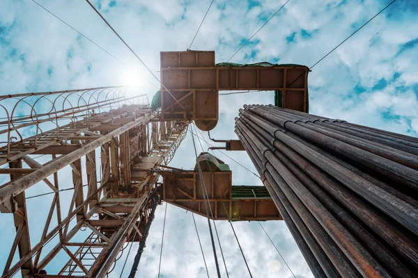 Oil and Gas Drilling Rig onshore dessert with dramatic cloudscape. Oil drilling rig operation on the oil platform in oil and gas industry — Stock Photo, Image