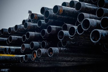 Petrol sondaj borusu. Paslı matkap boruları kuyu bölümünden delinmiş. Delik sondaj kulesi. Güverteye boru döşemek. Petrol ve benzin deposunun avlusundaki sondaj borularının görüntüsü.
