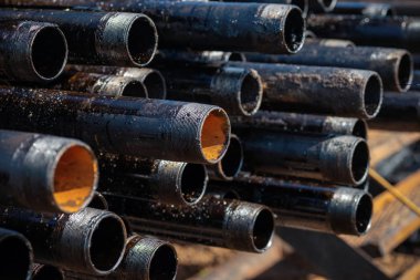 Petrol ve benzin deposunun açık avlusundaki sondaj borularının ve boruların görüntüsü.