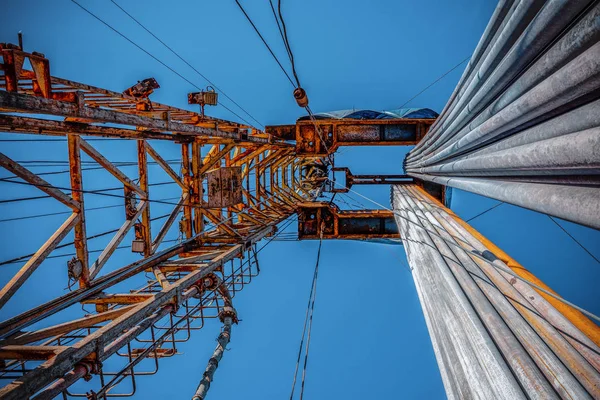 Appareil terrestre terrestre dans l'industrie pétrolière et gazière. plate-forme de forage pétrolier contre un ciel bleu avec des nuages . — Photo