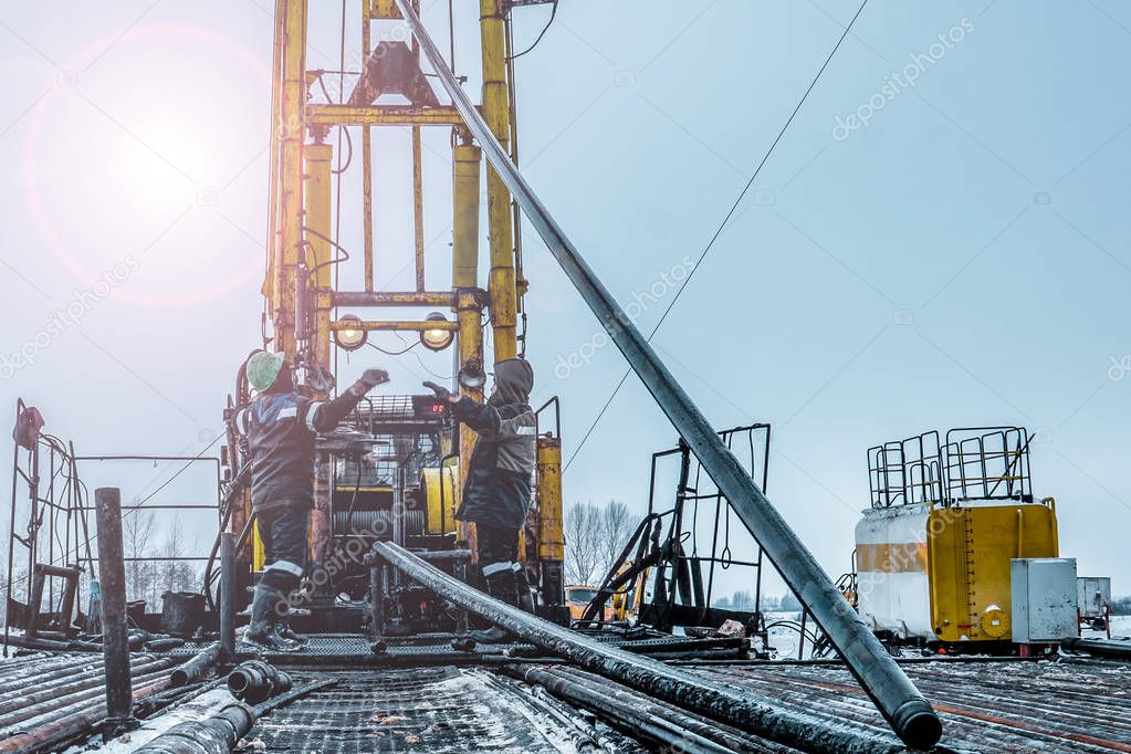 Offshore oil rig worker prepare tool and equipment for perforation oil and gas well at wellhead platform. Making up a drill pipe connection. A view for drill pipe connection from between the stands