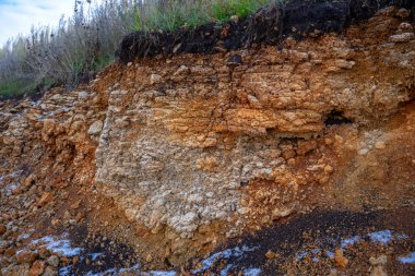 Toprak kesme kumtaşı, taşlar, kil, kum yapısı ve tabakaları. farklı yapıların katmanları ile kum dilim. Tortul kumtaşı kaya katmanları.