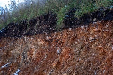 Toprak kesme kumtaşı, taşlar, kil, kum yapısı ve tabakaları. farklı yapıların katmanları ile kum dilim. Tortul kumtaşı kaya katmanları.