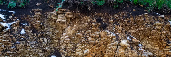 Soil cut-arenaria, pietre, argilla, struttura di sabbia e strati. fetta di sabbia con strati di diverse strutture. Strati di roccia arenaria sedimentaria . — Foto Stock