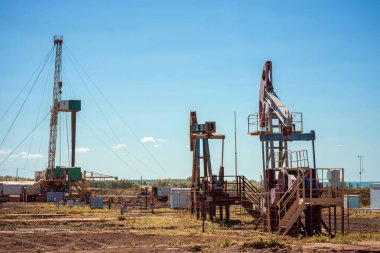 Petrol pompası arka planda boru hattıyla sallanıyor. Güç üretimi için sallanan makineler. Petrol çıkarımı.