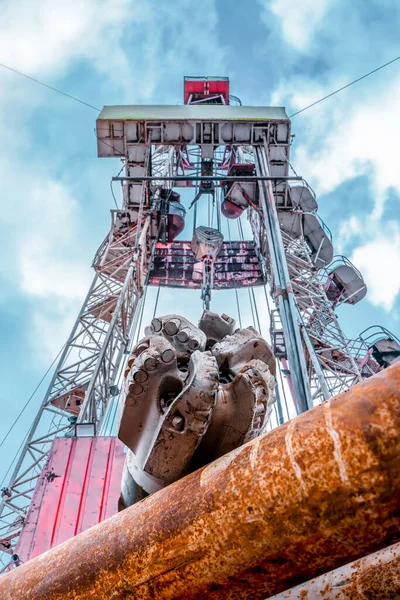 Oil and Gas Drilling Rig onshore dessert with dramatic cloudscape. Oil drilling rig operation on the oil platform in oil and gas industry — Stock Photo, Image