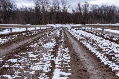 Kirli, pis, çamurlu, çamurlu, çamurlu, çatlak ve tekdüze çamurlu toprak bir yol. Off-road. Arkaplan