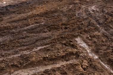 Kirli, pis, çamurlu, çamurlu, çamurlu, çatlak ve tekdüze çamurlu toprak bir yol. Off-road. Arkaplan