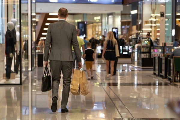Genç adam alışveriş merkezinde elinde bir sürü alışveriş torbasıyla alışveriş yapıyor.. — Stok fotoğraf
