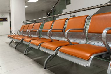 Havaalanında bir sıra boş koltuk. Kapatın. Çapraz kompozisyon. Kavram. Koronavirüs salgını sırasındaki uçuş iptallerinin konusu. Havaalanında bekleyenler için sıra sıra sandalye..