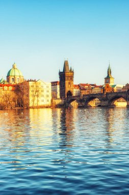 Prague, Çek Cumhuriyeti - Nisan 04: Vltava Nehri ve Charles Köprüsü manzarasına tuttu günbatımı güneş ile Prague, Çek Cumhuriyeti