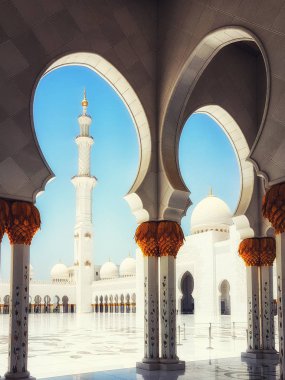 Abu Dhabi, Birleşik Arap Emirlikleri - 20 Haziran 2018: Şeyh Zayed Ulu Camii Abu Dhabi, Birleşik Arap Emirlikleri sermaye city. Sütunlar arasında yürüyen insanlar. Mavi gökyüzü güneşli gün
