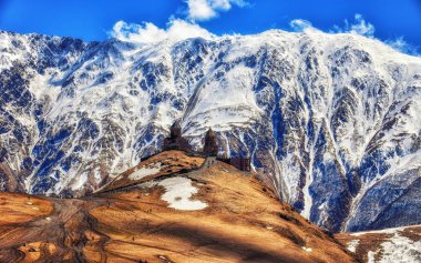 Stepansminda, Gürcistan - 15 Nisan 2017: 14. yüzyıl Gergeti Trinity Kilisesi (Gürcü Ortodoks) yüksek yukarıda Stepantsminda Kafkasya dağlarında
