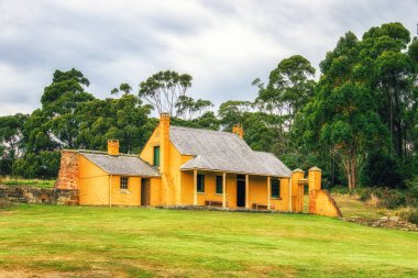 Küçük bir ev, Port Arthur, tarihi sitenin parçası çimenli yamaçta oturur.