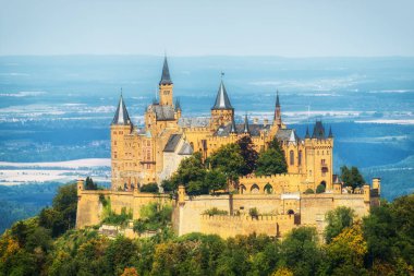 Hechingen, Almanya - 17 Ağustos 2018: Hava görünümünü ünlü Hohenzollern Kalesi, atalarının koltuk Hohenzollern İmparatorluk ev ve bir Avrupa'nın en çok ziyaret edilen kale, güzel altın akşam ışığı, Baden Wurttemberg, Almanya