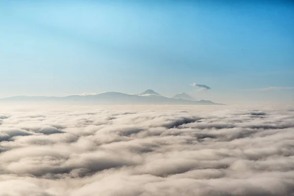 View above the clouds with in the distance the popocatepetl volcano, Mexico.