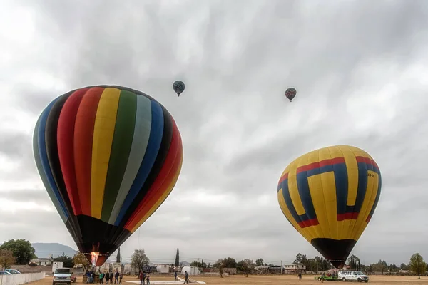 Men fill up hot air balloon in the early morning at Mexicos Archaeological Zone of Teotihuacan