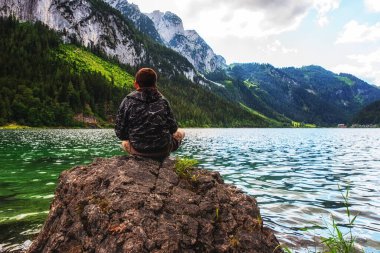 Avusturya 'nın yukarısındaki güzel Gosausee gölüne bakan genç bir çocuk..