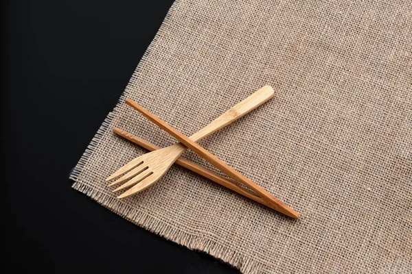 Набір дерев'яних бамбукових столових приборів: виделка і палички на мокрій тлі з копіювальним простором. Вид зверху — стокове фото