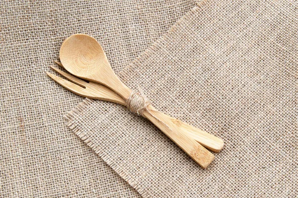 Set of wooden bamboo cutlery: fork and spoon on sackcloth background. Flat lay — Stock Photo, Image