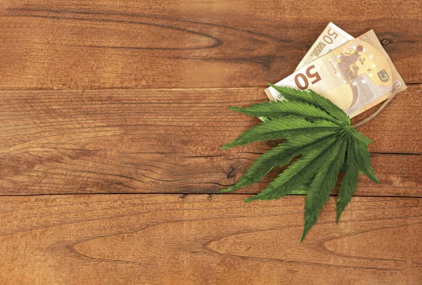 Cannabisblad och eurosedlar på träbordet, plana — Stockfoto