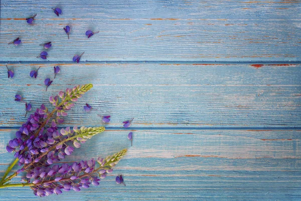 Summer flowers of purple lupine on the gently blue boards of the kitchen table