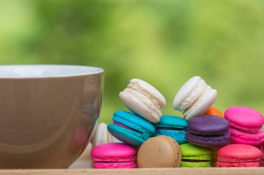 Ahşap masa üzerinde çanak kahve ve Renkli Macaroons Fincan