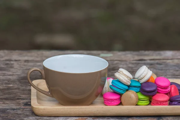 Cup of coffee and Colorful Macaroons in dish on wooden table — Stock Photo, Image