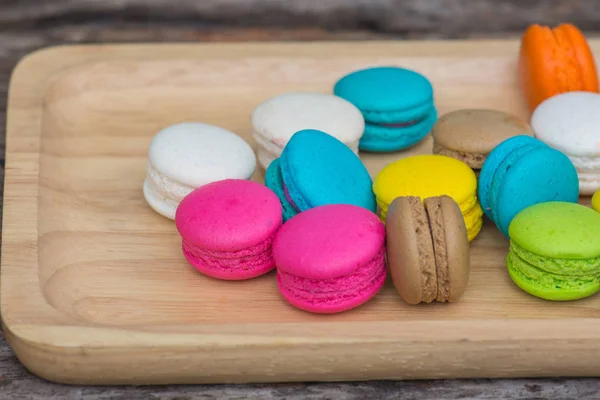 Macarons colorés dans un plat sur une table en bois — Photo