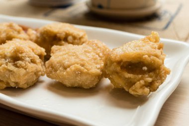 Altın kızarmış tavuk nuggets arka planda domates soslu beyaz plaka üzerinde