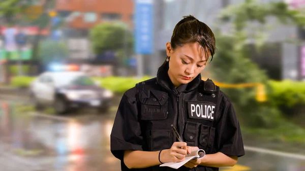 アジア系アメリカ人女性警察官犯罪現場メモを取るで — ストック写真