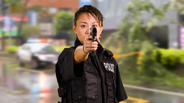 Asian American Woman Police Officer at Crime scene Pointing Gun