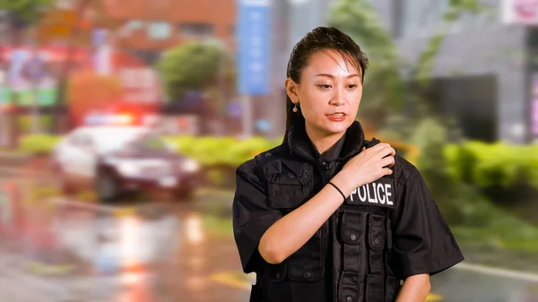 Asian American Woman Police Officer at Crime scene Talking on CB Radio