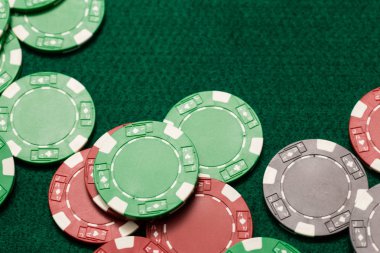 Yeşil tablo üzerinde dağınık casino fişi