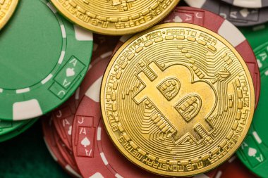 Bitcoin cryptocurrency yeşil masada dağınık casino fişi üzerinde
