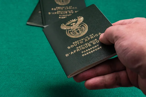 在绿色背景下手工传递南非护照 — 图库照片