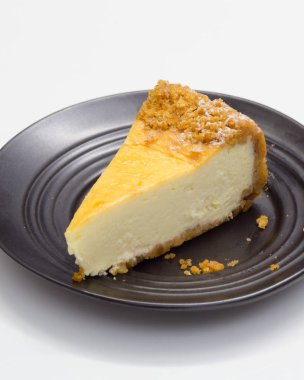 Beyaz masa üzerinde siyah daire üzerinde cheesecake