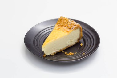 Beyaz masa üzerinde siyah daire üzerinde cheesecake