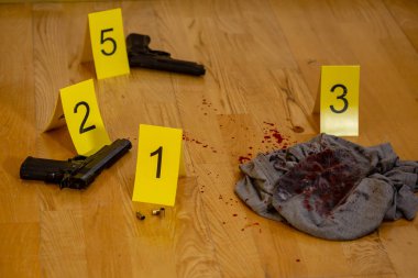 Mermi kovanları. kanlı kıyafetleri ve silahı olay yerinde işaretleri yanında