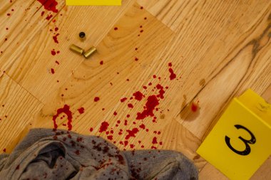 Mermi kovanları. kanlı kıyafetleri ve silahı olay yerinde işaretleri yanında