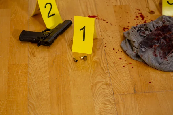 弾丸のケーシング 血まみれの服と銃犯罪現場でマーカーの横にあります — ストック写真