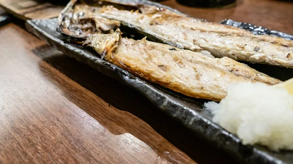 Poisson servi pendant la cuisson sur le plat au restaurant japonais izakaya — Photo